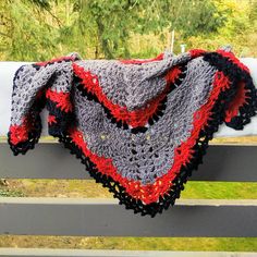 a crocheted blanket sitting on top of a wooden bench