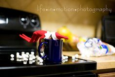 a coffee mug with marshmallows on it sitting in front of an oven