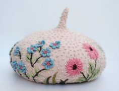 a pink and blue flowered purse sitting on top of a white table