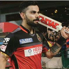 a man holding a bat in his hand while standing next to a crowd at a sporting event