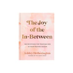 the joy of the in - between book with pink watercolor background and gold lettering