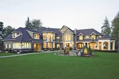 a large house with lots of windows in the front and side of it at night