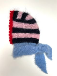 a knitted hat with a blue and pink ribbon tied around the top on a white background