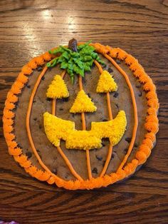 a decorated cookie with orange icing and trees in the shape of a jack - o'- lantern