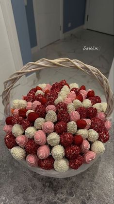 a basket filled with strawberries and white chocolate candies on top of a counter