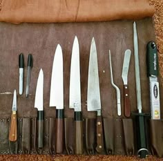 knives are lined up on a brown cloth