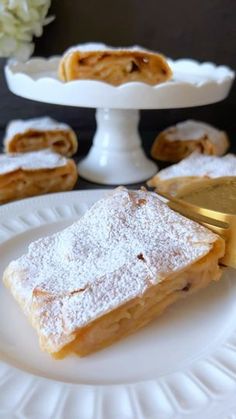 some food is on a white plate and there are other desserts in the background