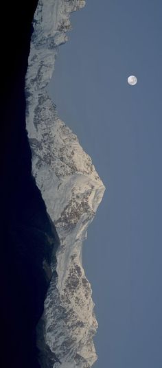 the moon shines brightly above an icy mountain