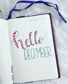 an open notebook with the words hello december written in cursive writing