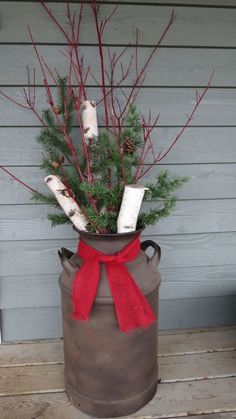 a potted plant with red ribbon tied around it on a wooden deck next to a house