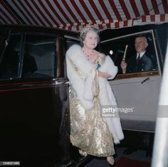 an older woman in a gold dress and fur coat exiting a car