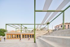 people are walking up and down the stairs in an open area with green railings