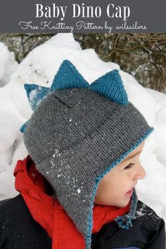 a young boy wearing a knitted hat in the snow with text overlay that says baby dino cap