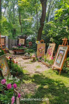 an outdoor area with paintings and flowers in the foreground, surrounded by greenery