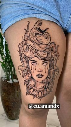 a woman with a snake tattoo on her thigh