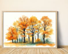 watercolor painting of trees with yellow and orange leaves on the branches, in front of a white wall