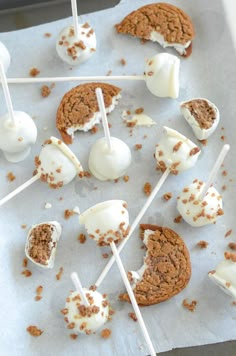 marshmallows and cookies are arranged on a sheet of paper with toothpicks