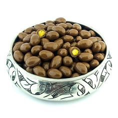 a silver bowl filled with chocolate covered almonds