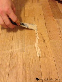 a person is using a knife to cut up something on the wood floor with scissors