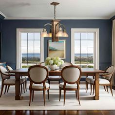 an elegant dining room with blue walls and white carpeted flooring is pictured in this image