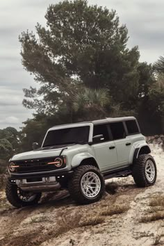 a gray truck driving down a dirt road