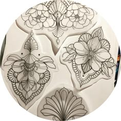 four different designs on a white plate in the shape of flowers and leaves are shown