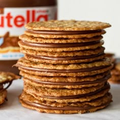 a stack of cookies sitting next to a jar of nutella