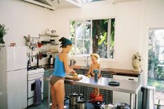 two young women are preparing food in the kitchen