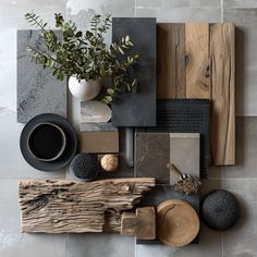 various materials are arranged on the floor next to a vase with plants in it and some rocks