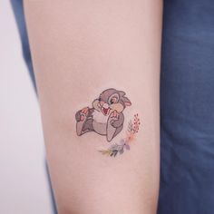 a woman's arm with a small tattoo of a cat on the left side