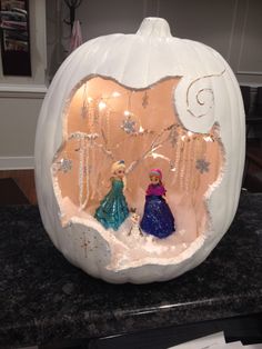 a white pumpkin decorated with frozen princesses and snowflakes