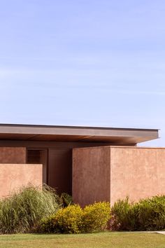 a building with grass and bushes in front of it