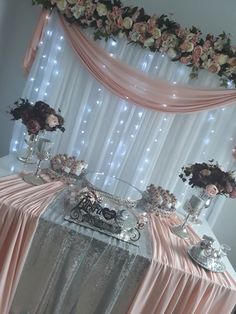 the table is covered with pink and white flowers, silverware and other decorative items