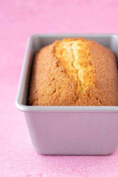 a close up of a loaf of bread in a pan on a pink table top