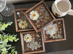 three wooden trays with flowers painted on them next to a cup and saucer