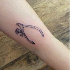 a tattoo on the arm of a person with a knife and flowers in its claws