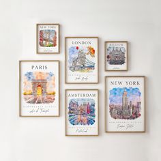 four framed pictures hang on the wall in front of a white wall with different cities