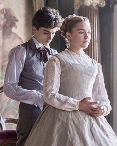 the young man and woman are dressed in period clothing