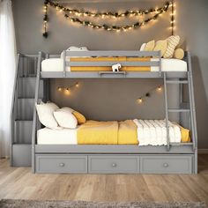 a bunk bed with two drawers underneath it and lights on the wall behind it in a bedroom