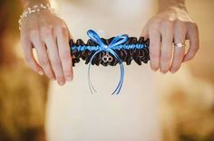 a person holding something in their hands with a blue ribbon around it's wrist