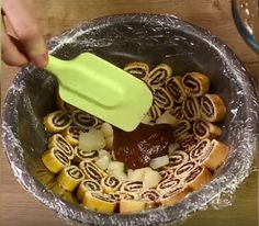 someone using a plastic spatula to stir food in a bowl on a table top