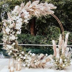 a wedding arch with flowers and feathers on it