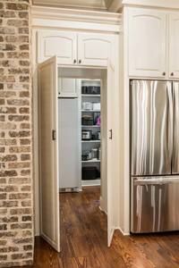 an open refrigerator in a kitchen next to a brick wall and hardwood floored floors