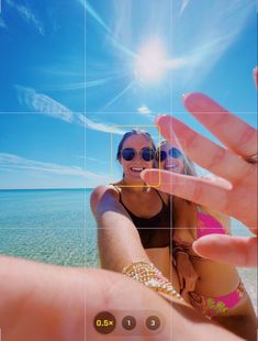 a person holding up their hand to take a photo with the sun in the background