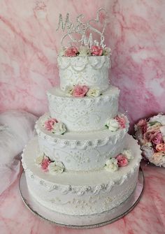 a three tiered wedding cake with pink and white flowers