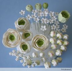 there are many flowers on the table with green stems and white flowers in them,