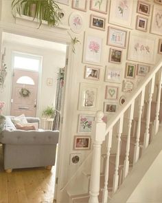 a living room filled with lots of pictures on the wall and a couch in front of it