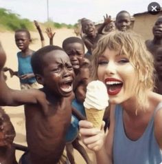 a woman holding an ice cream cone in front of a group of children on the beach