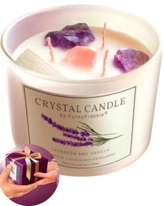 a candle that has some rocks in it and is next to a purple box with a bow