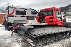 a snow plow is parked next to a trailer